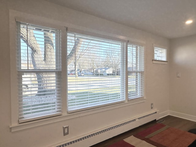 interior space featuring baseboards, baseboard heating, and wood finished floors