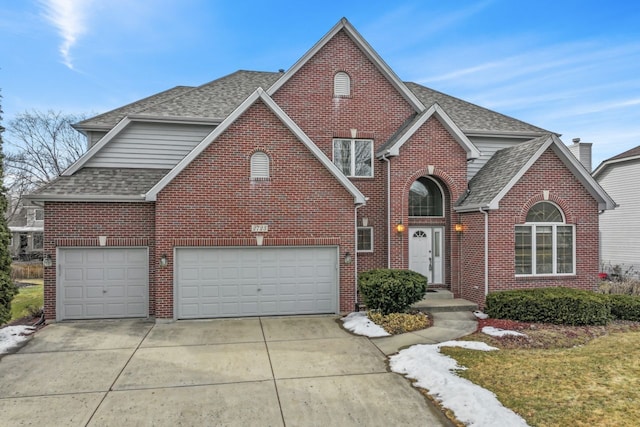 view of front of home with a shingled roof, concrete driveway, brick siding, and a garage