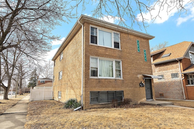 exterior space featuring fence and brick siding