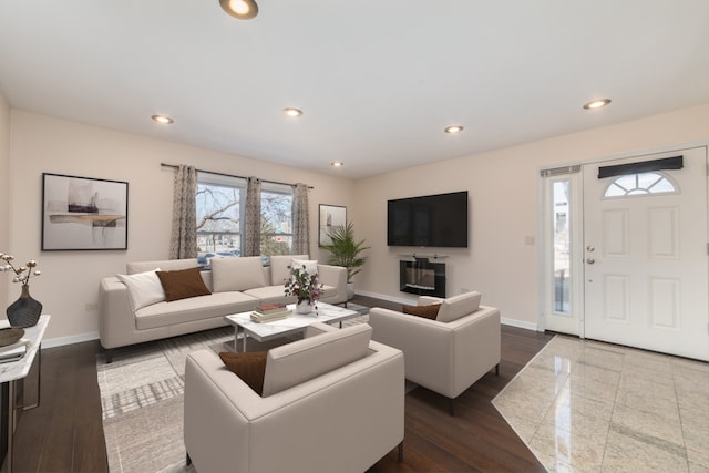 living area featuring baseboards, dark wood-type flooring, and recessed lighting