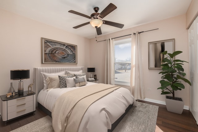 bedroom featuring a ceiling fan, baseboards, and dark wood-type flooring