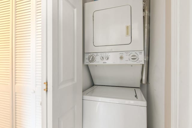 clothes washing area with laundry area and stacked washing maching and dryer