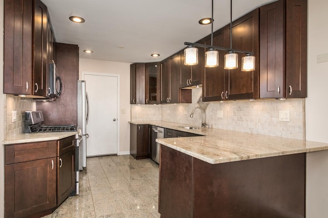 kitchen featuring a peninsula, a sink, dark brown cabinets, appliances with stainless steel finishes, and light stone countertops