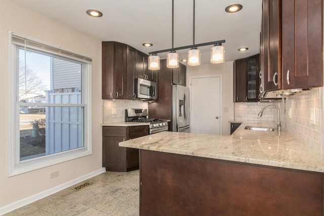 kitchen with baseboards, visible vents, appliances with stainless steel finishes, dark brown cabinets, and a sink