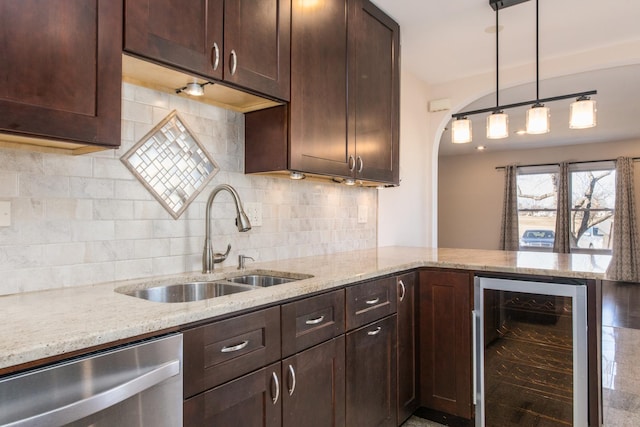 kitchen featuring wine cooler, dishwasher, a sink, and dark brown cabinets