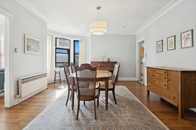 dining area with ornamental molding, radiator heating unit, and wood finished floors