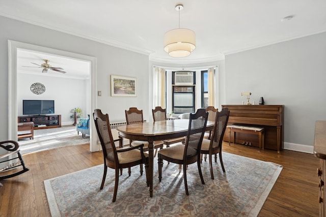 dining area with wood-type flooring, ornamental molding, baseboards, and a wall mounted AC