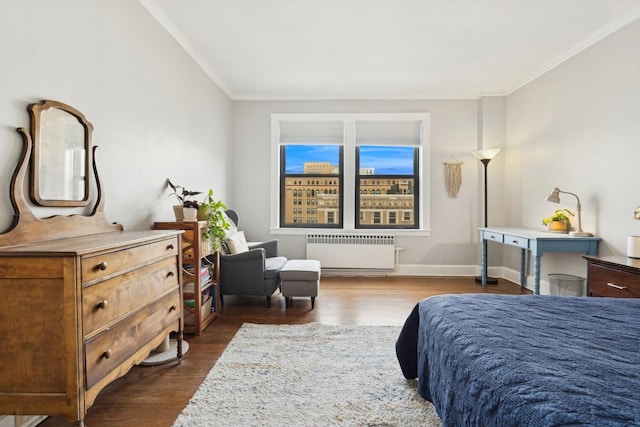 bedroom with ornamental molding, dark wood-type flooring, radiator heating unit, and baseboards