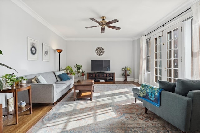 living room with ceiling fan, ornamental molding, wood finished floors, and baseboards