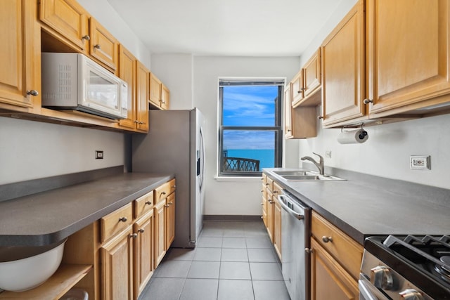 kitchen with open shelves, appliances with stainless steel finishes, dark countertops, and a sink