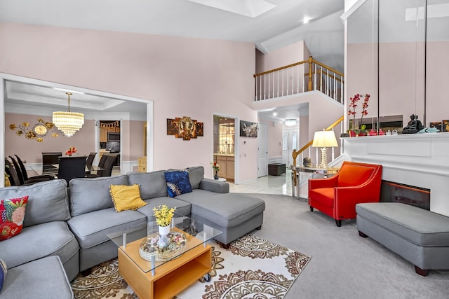 carpeted living area featuring stairs and high vaulted ceiling
