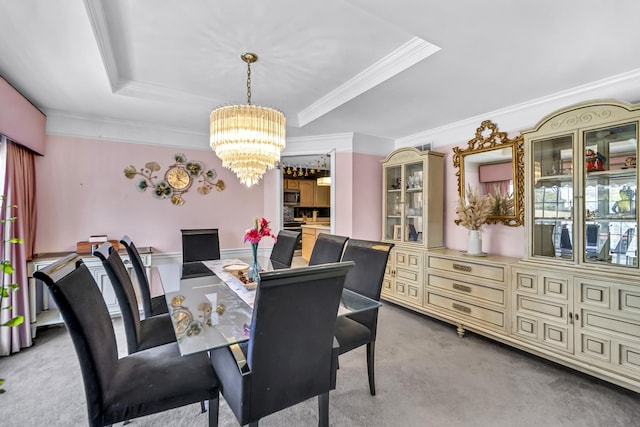 dining area with an inviting chandelier, light carpet, a raised ceiling, and ornamental molding