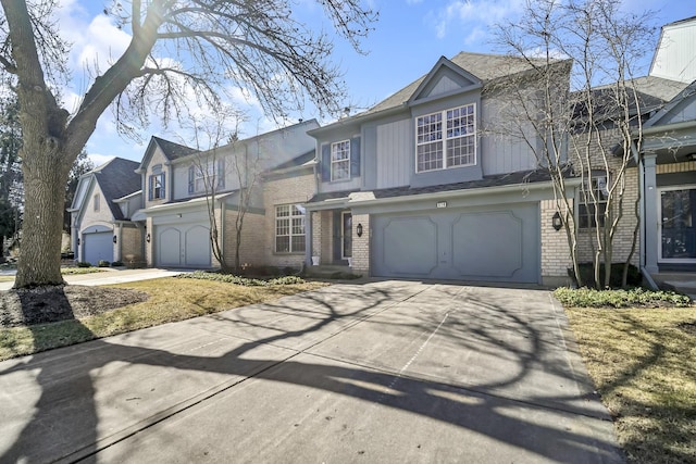 view of front facade featuring driveway, brick siding, a garage, and board and batten siding