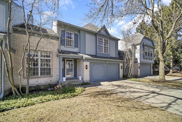traditional-style home with concrete driveway, brick siding, roof with shingles, and a garage
