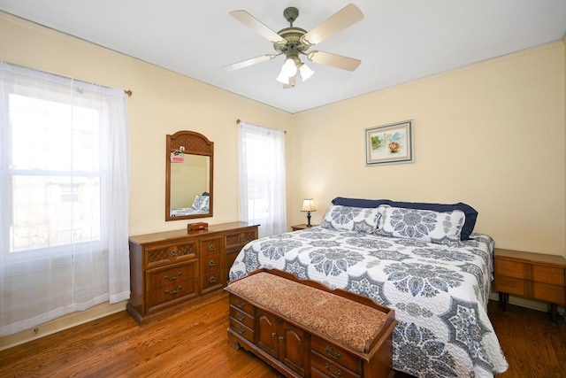 bedroom with ceiling fan, baseboards, and wood finished floors