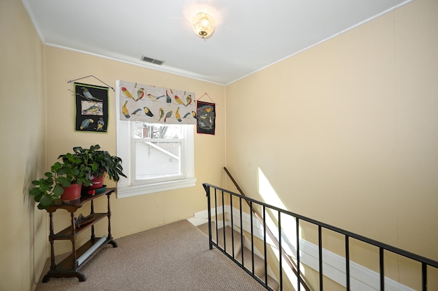 corridor featuring visible vents, an upstairs landing, and carpet