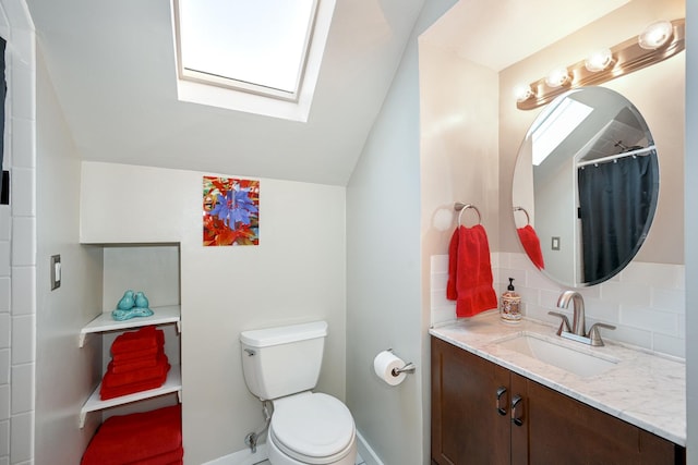 full bath featuring toilet, backsplash, vaulted ceiling with skylight, baseboards, and vanity