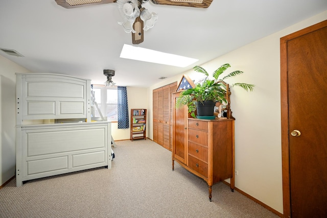 bedroom with light carpet, visible vents, a skylight, and baseboards