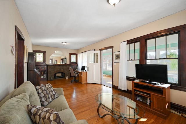 living area featuring a brick fireplace and wood finished floors