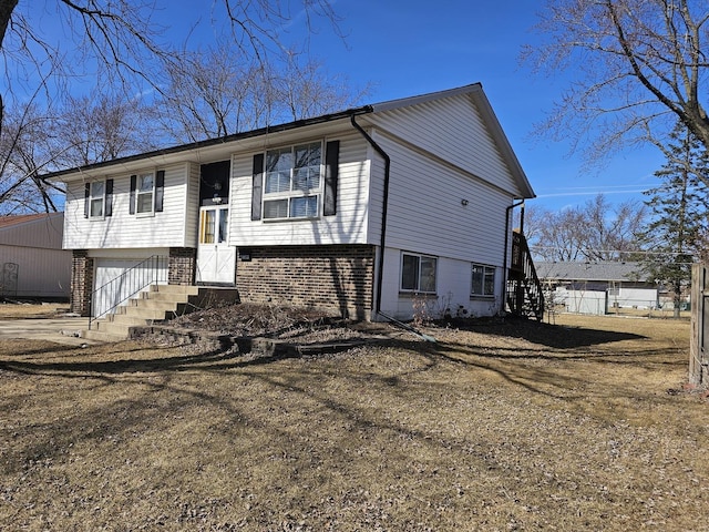 bi-level home featuring an attached garage and brick siding