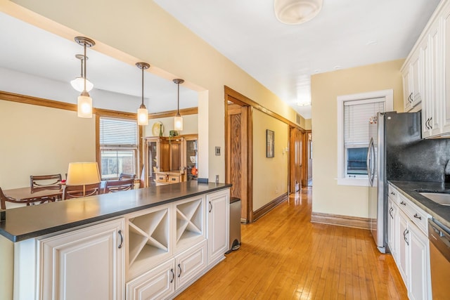 kitchen with dark countertops, a sink, and dishwashing machine