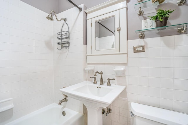 bathroom with toilet, a sink, tile walls, shower / washtub combination, and tasteful backsplash