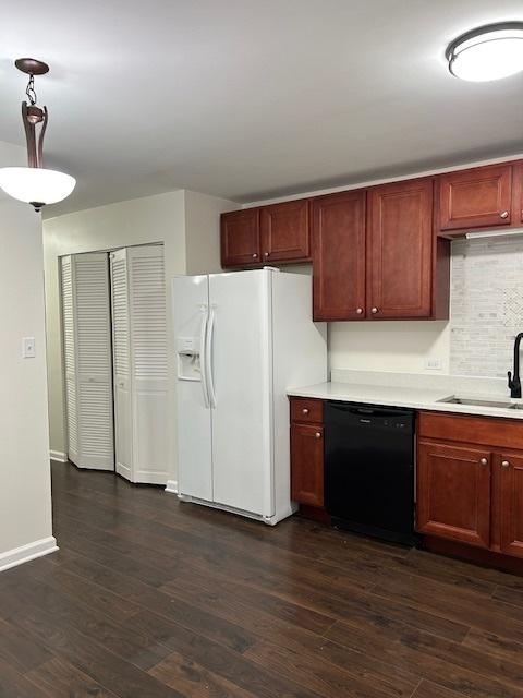 kitchen featuring white refrigerator with ice dispenser, dark wood-style flooring, a sink, light countertops, and dishwasher