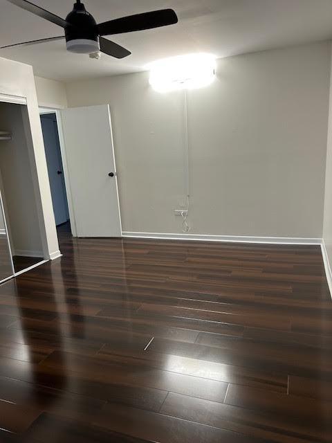 unfurnished room with a ceiling fan, baseboards, and hardwood / wood-style floors