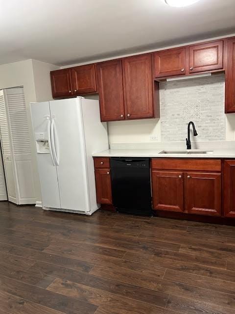 kitchen featuring dark wood-type flooring, a sink, black dishwasher, light countertops, and white fridge with ice dispenser