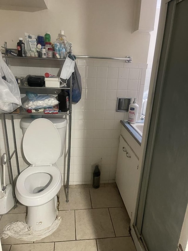 bathroom with tile patterned flooring, tile walls, toilet, and vanity