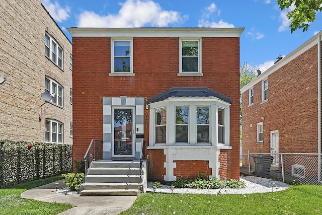 view of front facade featuring brick siding and fence