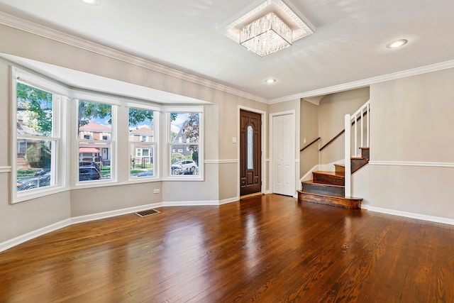 foyer entrance featuring stairway, hardwood / wood-style flooring, visible vents, and crown molding