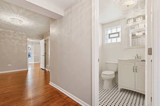 bathroom featuring toilet, wood finished floors, visible vents, vanity, and baseboards