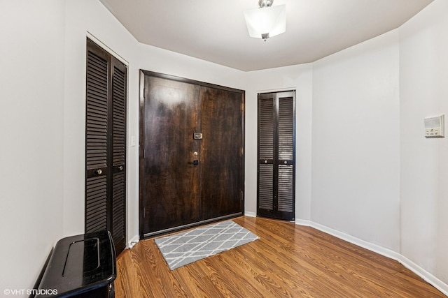 entrance foyer featuring baseboards and wood finished floors