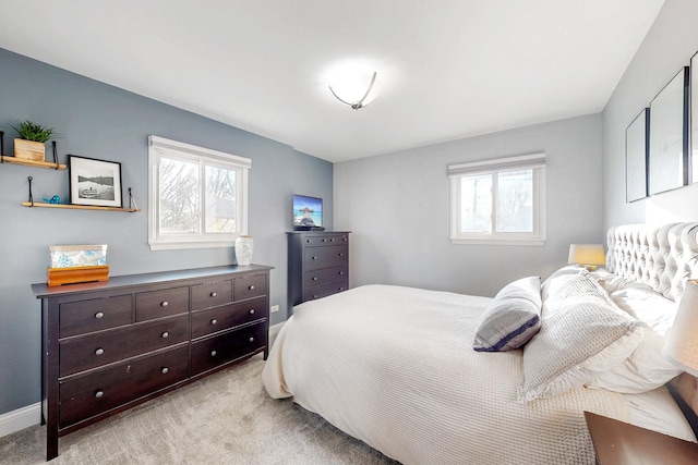 bedroom with baseboards, multiple windows, and carpet