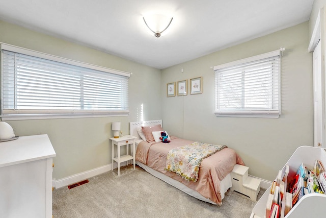 carpeted bedroom featuring visible vents and baseboards