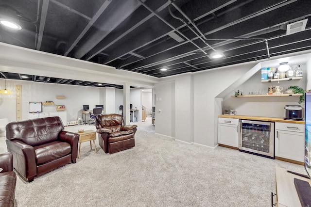 living area with baseboards, light carpet, beverage cooler, and a dry bar