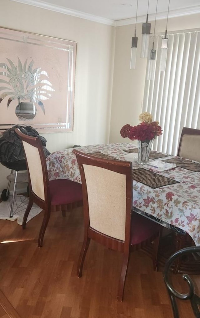 dining room with wood finished floors and ornamental molding