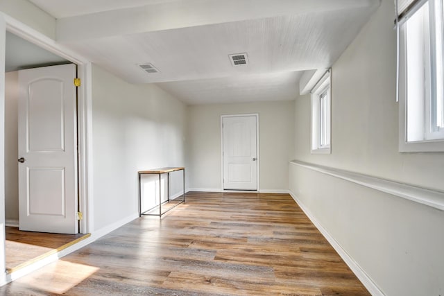 empty room with visible vents, baseboards, and wood finished floors