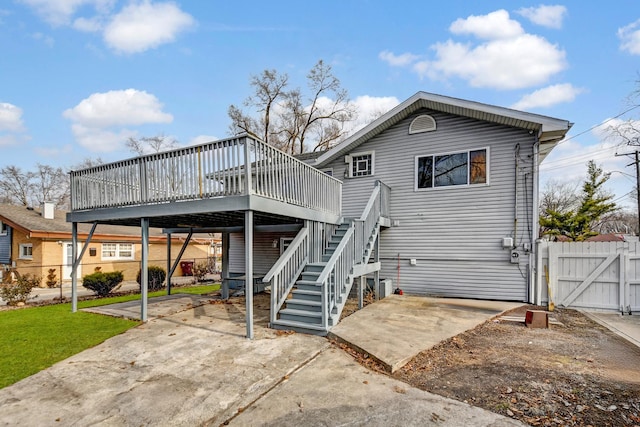 rear view of house featuring stairs, a gate, fence, and a patio