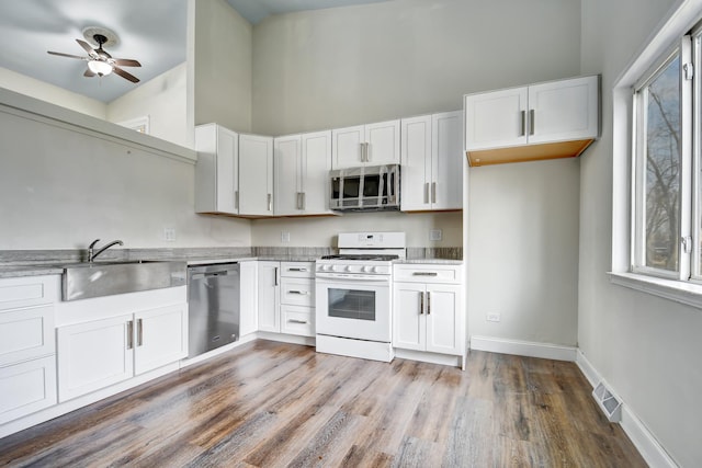 kitchen featuring appliances with stainless steel finishes, a sink, visible vents, and white cabinets