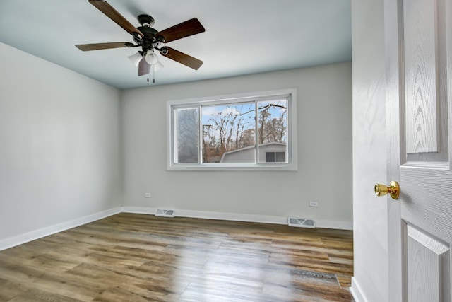 spare room featuring a ceiling fan, baseboards, visible vents, and wood finished floors