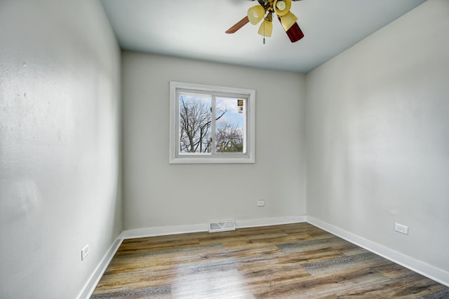 spare room featuring a ceiling fan, baseboards, visible vents, and wood finished floors