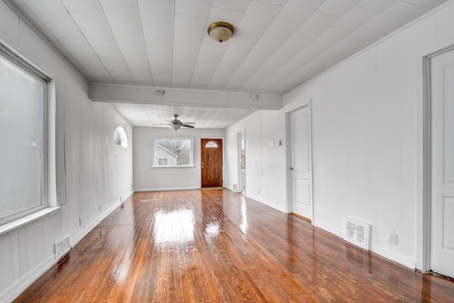 unfurnished living room with baseboards, ceiling fan, visible vents, and hardwood / wood-style floors