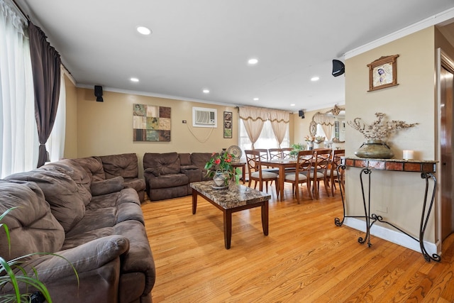 living room with ornamental molding, light wood-type flooring, a wall mounted air conditioner, and recessed lighting