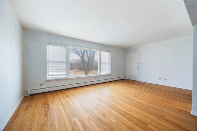 unfurnished room with a baseboard radiator and wood finished floors