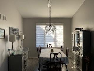 dining area with dark wood finished floors, visible vents, and baseboards