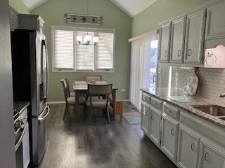 dining area with lofted ceiling and dark wood-style floors