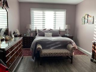 bedroom featuring baseboards and wood finished floors