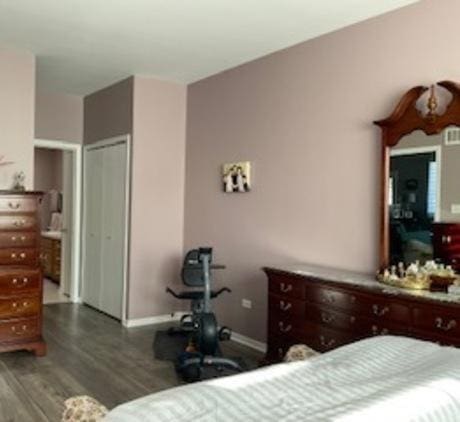 bedroom featuring a closet, baseboards, and wood finished floors